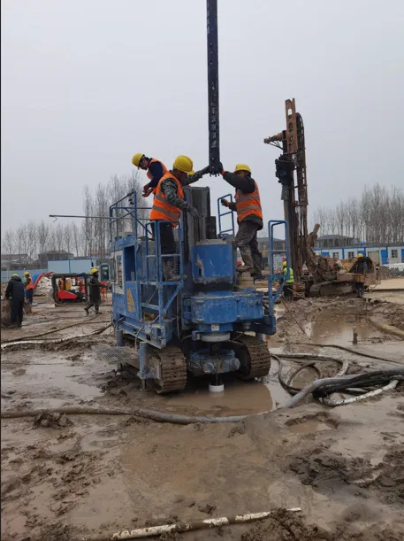 Workers installing drill pipe on SJL-120 rig for jet grouting